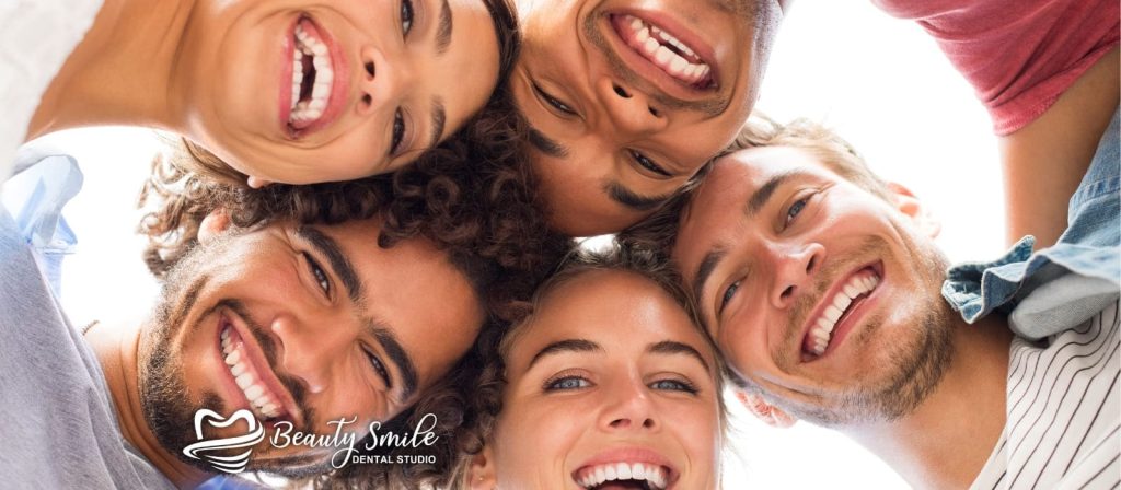 Jóvenes sonriendo felices por los ahorros dentales que recibieron en Beauty Smile Dental Studio en Tijuana, destacando los beneficios del turismo dental y la habilidad de los dentistas en Tijuana