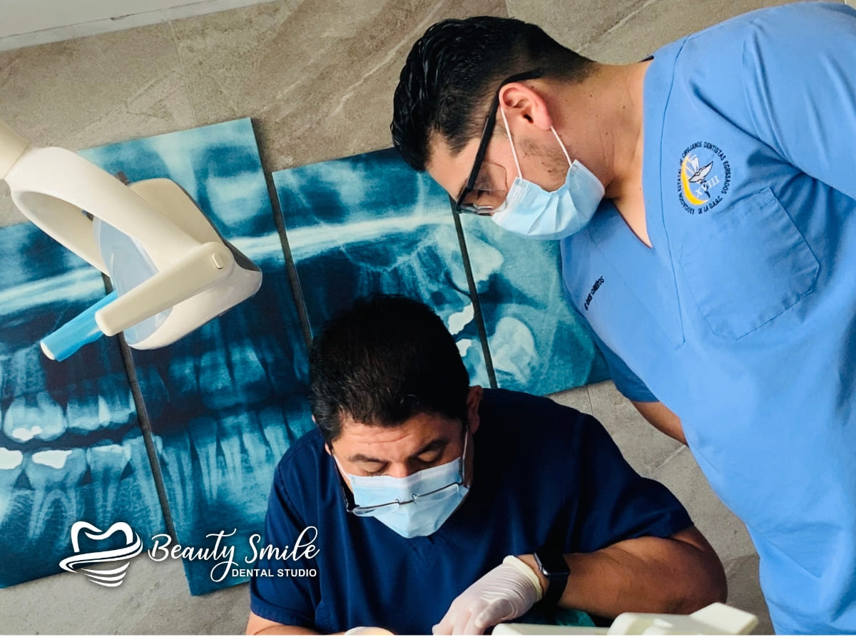 Dr. Pablo Alba y su asistente trabajando juntos en el consultorio de Beauty Smile Dental Studio, enfocados en la atención al paciente.